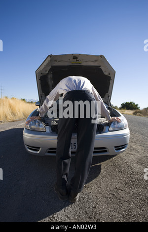 Vue arrière d'un businessman looking at un moteur de voiture Banque D'Images