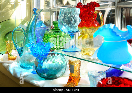 Plats en verre coloré en exposition dans un magasin d'Antiquités Banque D'Images