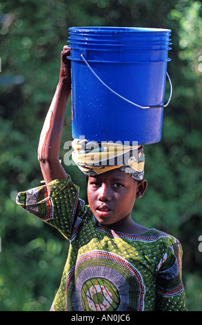 Fille d'Utende avec un seau d'eau en équilibre sur sa tête de l'île Mafia Mafia se trouve entre Zanzibar et le nord du Mozambique Banque D'Images