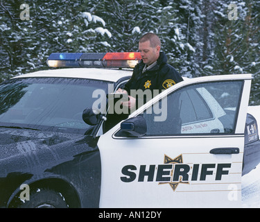 Un agent de police federale prend part à un barrage routier sur une autoroute enneigée près de Klamath Falls Oregon Banque D'Images