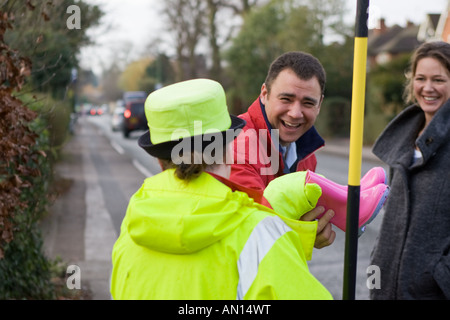 La 'lollipop lady' aide un homme et une femme à traverser la rue Banque D'Images