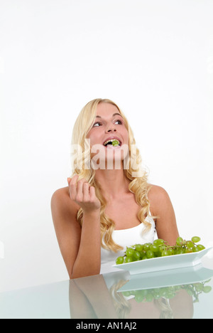 Young woman enjoying green grapes Banque D'Images