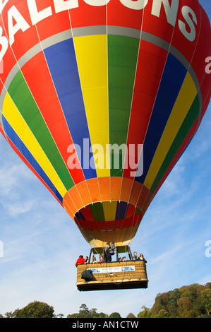 Les gens à l'air chaud ballon panier voler juste au-dessus des arbres Banque D'Images