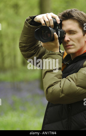 Photographe de prendre des photos dans un bois bluebell en Angleterre Banque D'Images