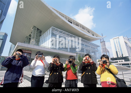 La Chine, Shanghai, les enfants prenant des photos en face de la Shanghai Grand Theatre de la Place du Peuple Banque D'Images