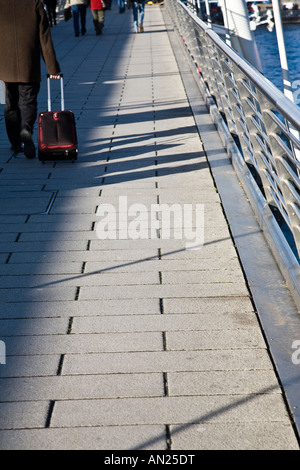 Les piétons qui traversent l'un des Golden Jubilee Bridges qui flanquent le Hungerford railway bridge, Londres, Angleterre. Banque D'Images
