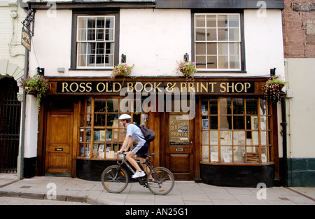 Circonscription cycliste sur la chaussée passé Ross vieux livre et l'imprimerie en Ross on Wye Herefordshire Angleterre UK Banque D'Images