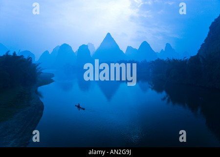 Matin Bleu évocateur théâtre de pics calcaires et cormorant fisherman dans Yangshuo, Chine Banque D'Images