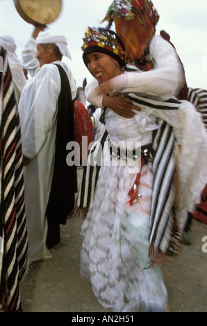 Femme berbère porte une mariée voilée sur son dos pendant une simulation de mariage à l'Imilchil Brides juste le Haut Atlas Maroc Banque D'Images