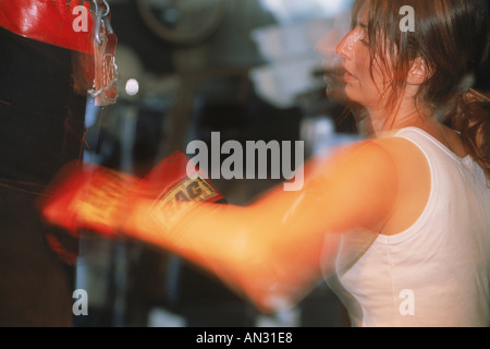 Femme Sac de frappe frapper avec des gants de boxe Banque D'Images