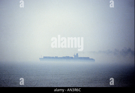 Porte-conteneurs dans le brouillard de quitter le port de Felixstowe, Suffolk, UK. Banque D'Images