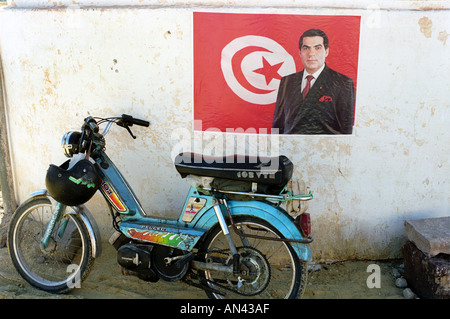 Une affiche pour le président tunisien Ben Ali à côté de l'un des nombreux cyclomoteurs utilisés dans le pays Banque D'Images