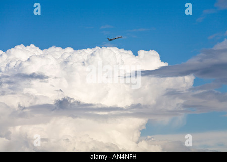 Jet Commercial escalade au-dessus de nuages dans le ciel bleu Banque D'Images