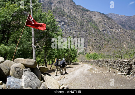 Pierres avec Mantra bouddhiste et drapeau communiste. Khotro laissant village. Circuit de l'Annapurna trek. Le Népal Banque D'Images