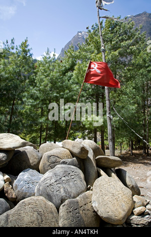 Pierres avec Mantra bouddhiste et drapeau maoïste. Khotro Hors village. Circuit de l'Annapurna trek. Le Népal Banque D'Images