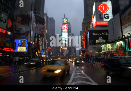 Times square new york city manhattan USA pendant une tempête de pluie avec un taxi à l'avant-plan Banque D'Images