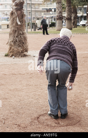 Un vieil homme jouant de la pétanque à Antibes France Mouvement sur personne s main droite Copy space Banque D'Images