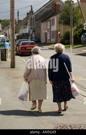 Deux vieilles femmes marcher jusqu'à la rue, village près de Cilgerran Pembrokeshire Cardigan , après-midi d'été, Pays de Galles, Royaume-Uni Banque D'Images