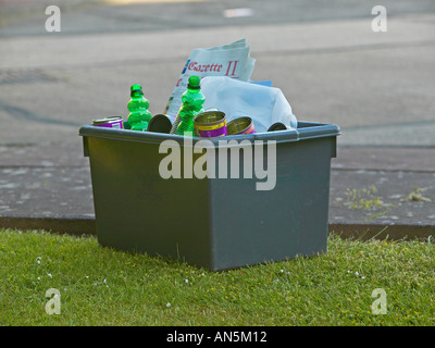 Boîte grise accueil recyclage, rempli et en attente pour la collecte en bordure de rue Banque D'Images