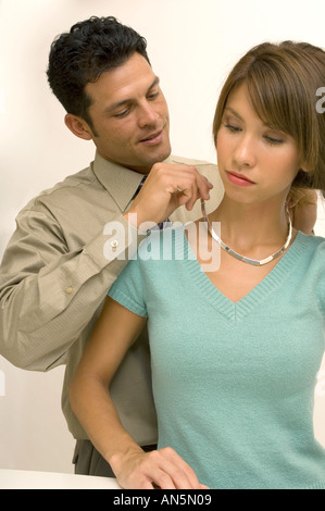 Portrait d'un homme d'aider une femme à mettre un collier Banque D'Images