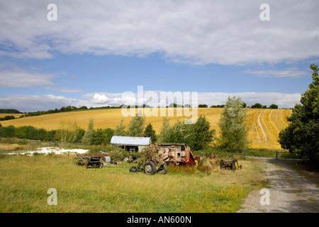 Ancienne grange et les tracteurs sur les terres agricoles dans le Wiltshire en Angleterre l'agriculture anglaise Banque D'Images