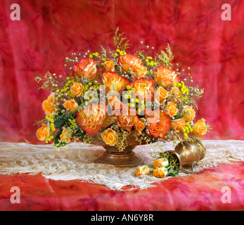 Studio jaune bouquet dessings organisé de rosiers en fleurs dans un vase sur un fond pastel rouge Banque D'Images