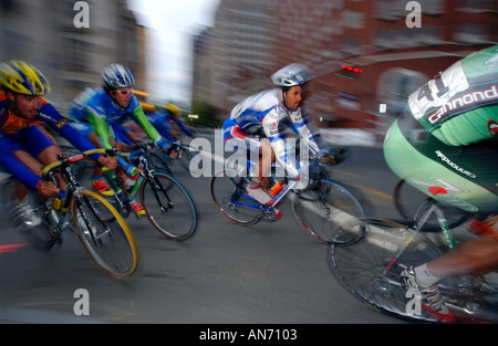 Bike racers course à travers une rue de la ville au crépuscule Banque D'Images