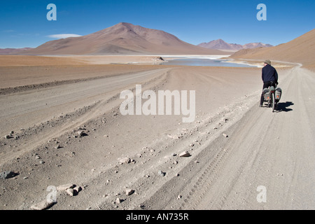 Cycliste sur route de gravier par Salar Chalviri, Boliva Banque D'Images