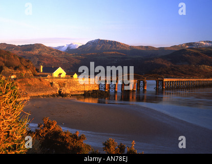 Pont de Barmouth et l'estuaire de Mawddach au coucher du soleil d'hiver, à la neige à la montagne Cader Idris dans Gwynedd au Pays de Galles UK Banque D'Images