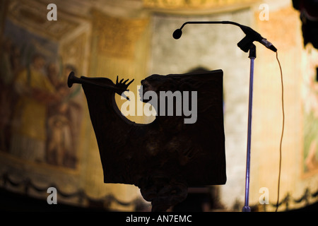 Un ange en bronze avec une trompette qui fait partie d'une chaire avec un microphone stand au-dessus des murs d'Or Banque D'Images