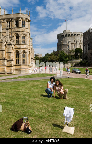 Château de Windsor, chapelle St Saint Georges à gauche et Tour ronde, touristes prenant une photo d'eux-mêmes. Panneau « ne pas approcher de l'herbe » sur les housses de tee-shirt. ROYAUME-UNI. Banque D'Images