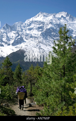 Les porteurs et ll'Annapurna (7937m). Sur le chemin de l'Upper Pisang village. Circuit de l'Annapurna trek. Le Népal Banque D'Images