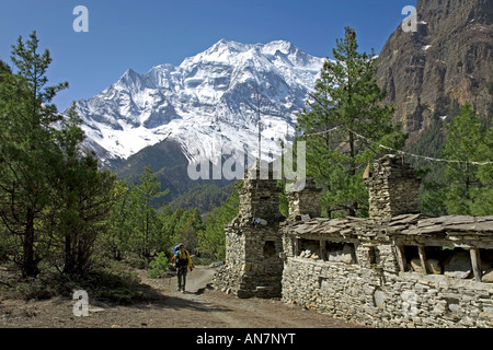 Trekker et mani mur. Sur l'arrière-plan l'Annapurna II (7937m). Circuit de l'Annapurna trek. Le Népal Banque D'Images