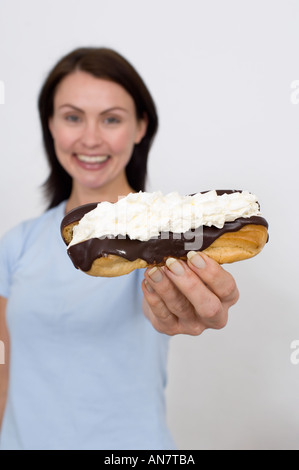 Femme tentant quelqu'un avec un chocolat et crème slice Banque D'Images