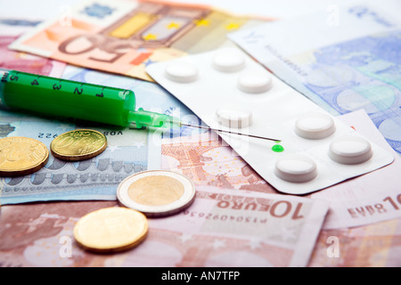 Medical seringue remplie de liquide vert et bande blanche de pilules couché sur l'introduction des billets et des pièces Banque D'Images