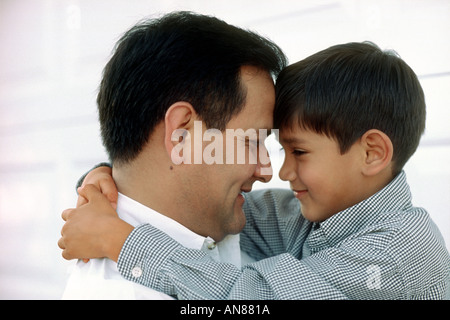 Portrait de 6 ans Mexican American boy hugging son Mexicain de 38 ans père américain Banque D'Images