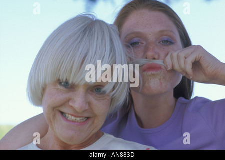 Portrait de 57 ans caucasien femme avec 22 ans qui fait une 'fausse moustache' avec sa mère les cheveux Banque D'Images