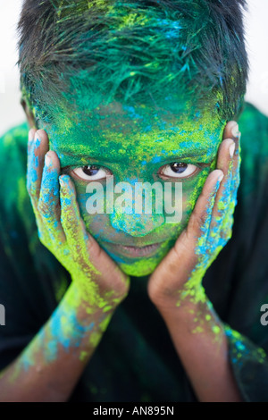 Jeune Indien garçon couvert de pigments en poudre de couleur Banque D'Images