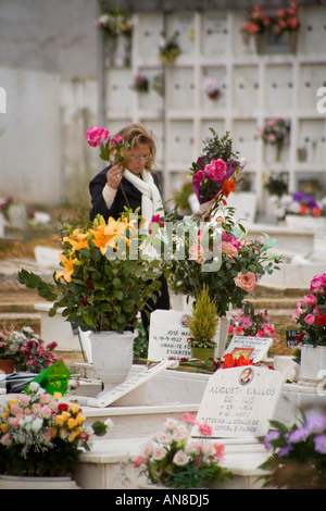 ESTORIL PORTUGAL Femme dans le cimetière prend les roses tombe d'un membre de la famille Banque D'Images