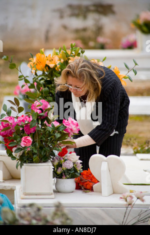 ESTORIL PORTUGAL Femme dans le cimetière prend les roses tombe d'un membre de la famille Banque D'Images