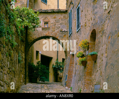 Toscane Italie Scène de rue avec des murs en pierre ronde et passage voûté dans la colline de San Quirico d'Orcia Banque D'Images