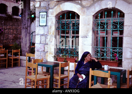 Une vieille dame bénéficie d'une tasse de thé dans le magnifique quartier Nachlaot Jérusalem Banque D'Images