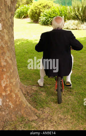 Un homme assis sur un vélo Banque D'Images