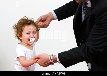 Crying baby girl holding à son père Banque D'Images