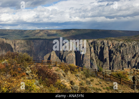 Pied clôturé Chemin menant le long de South Rim du Canyon à oublier avec lumière dramatique et petit Rainbow Black Canyon of the Gunnison Banque D'Images