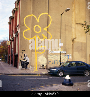 Ligne de peinture de fleur jaune Banksy street art et peintre avec un rouleau sur un mur à Pollard Street, Bethnal Green, Londres KATHY DEWITT Banque D'Images