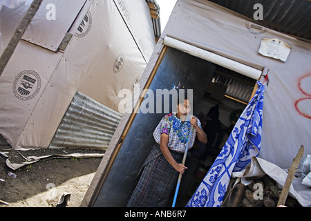 GUATEMALA Mayas Tzutujil TZANCHAJ femme en costume traditionnel balayant sa chambre temporaire dans un camp de réfugiés Banque D'Images