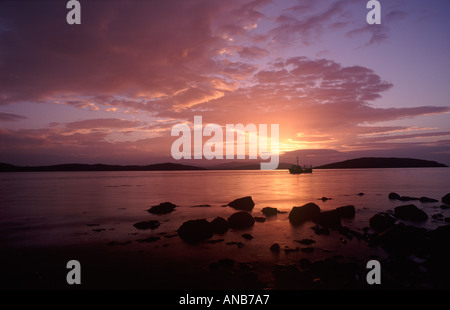 Bateau de pêche contre l'sillhouetted au lever du soleil sur l'Balcary Bay Solway Firth Dumfries et Galloway Scotland UK Banque D'Images