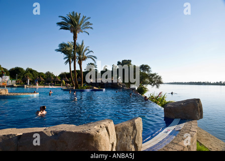 Movenpick Jolie Ville Luxor Hotel Île Crocodile personnes dans la piscine à débordement Nileside Banque D'Images