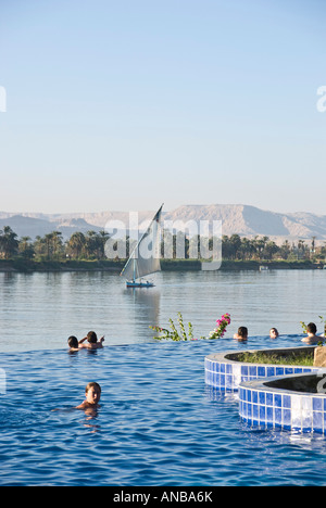 Movenpick Jolie Ville Luxor Hotel Île Crocodile personnes dans la piscine à débordement Nileside Banque D'Images